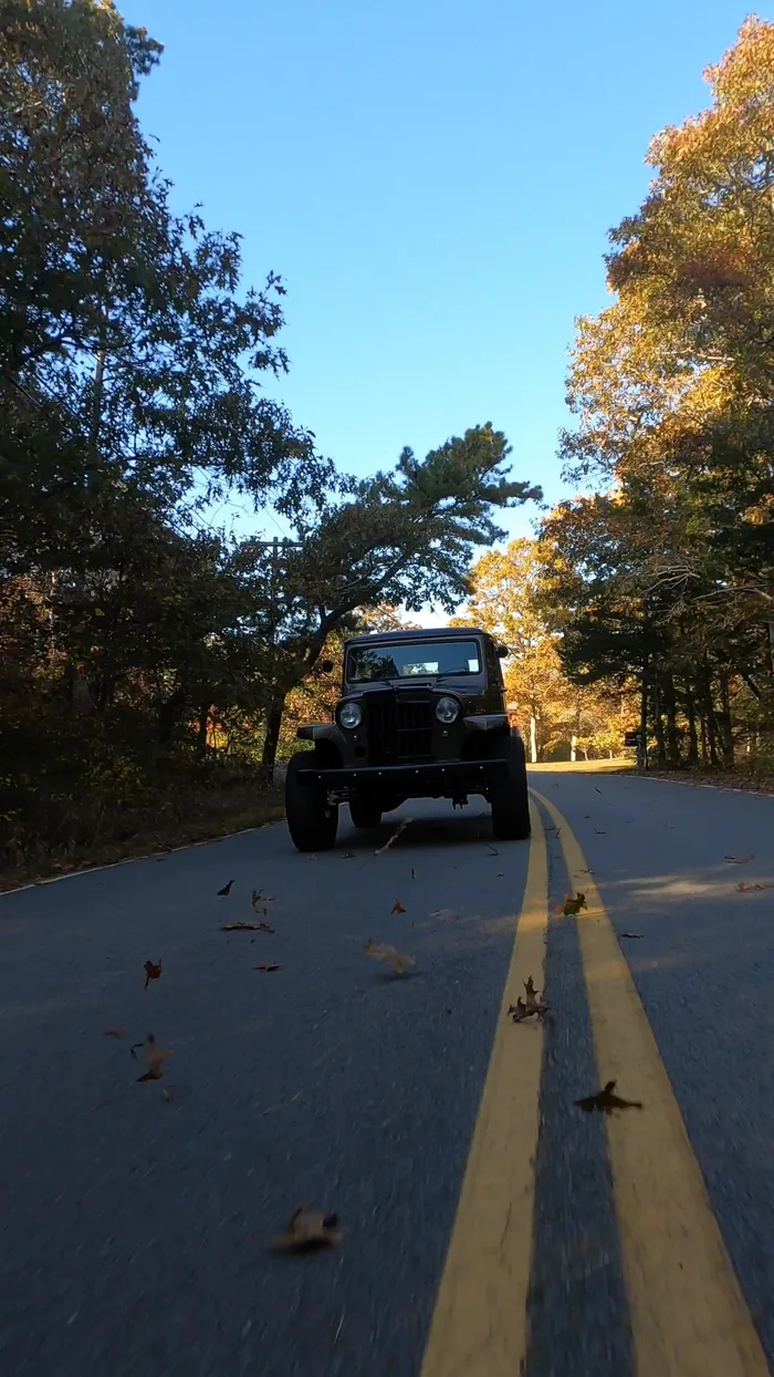 Classic black Jeep on an autumn road on Cape Cod