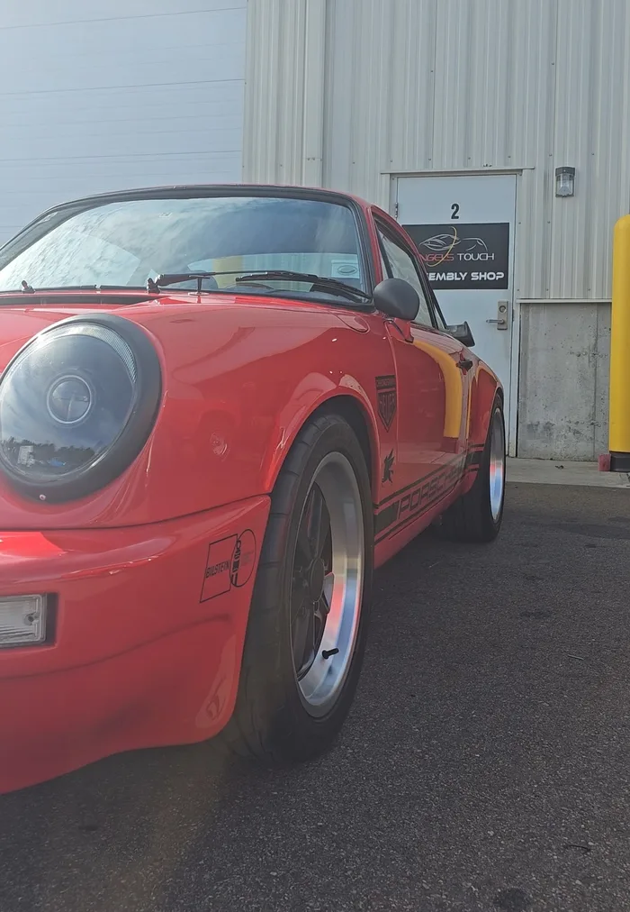 Red Porsche 911 parked outside the shop