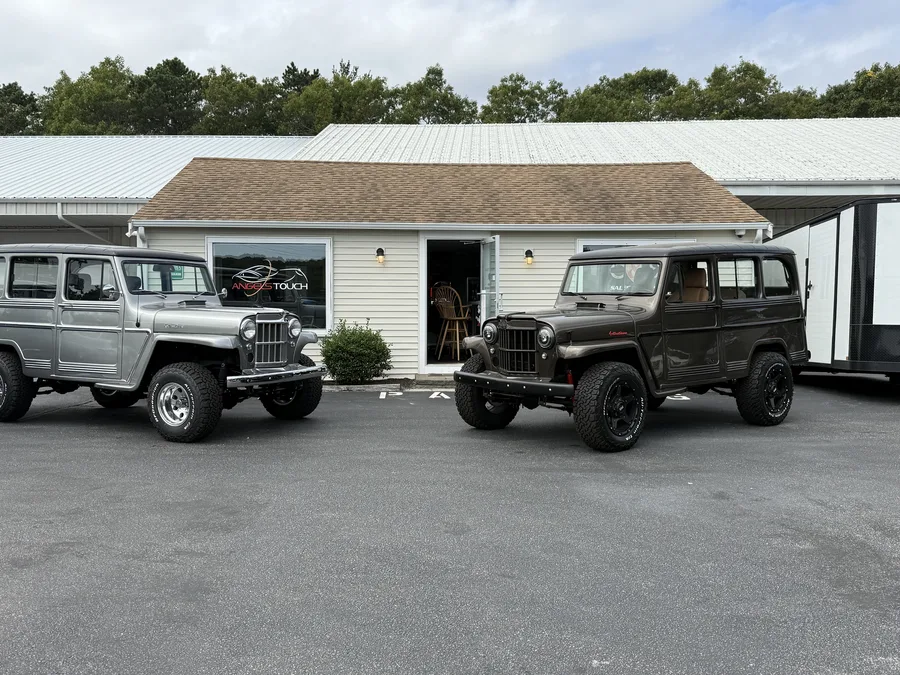 Two classic Willys jeeps parked in front of the Angels Touch shop