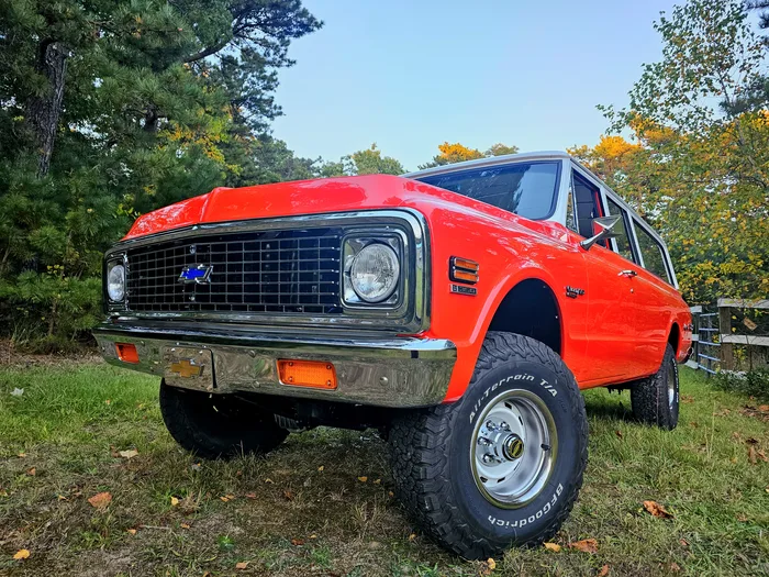 Front end of a restored red and white classic Chevrolet Suburban